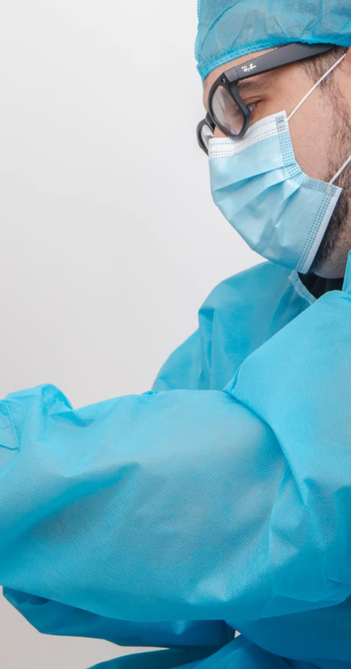 Médico de Cuida-T con bata estéril, mascarilla y guantes durante una valoración en consulta